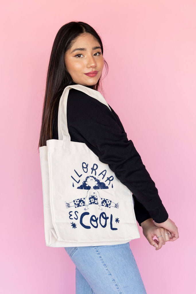 Model carrying tote bag with a blue hand drawn design