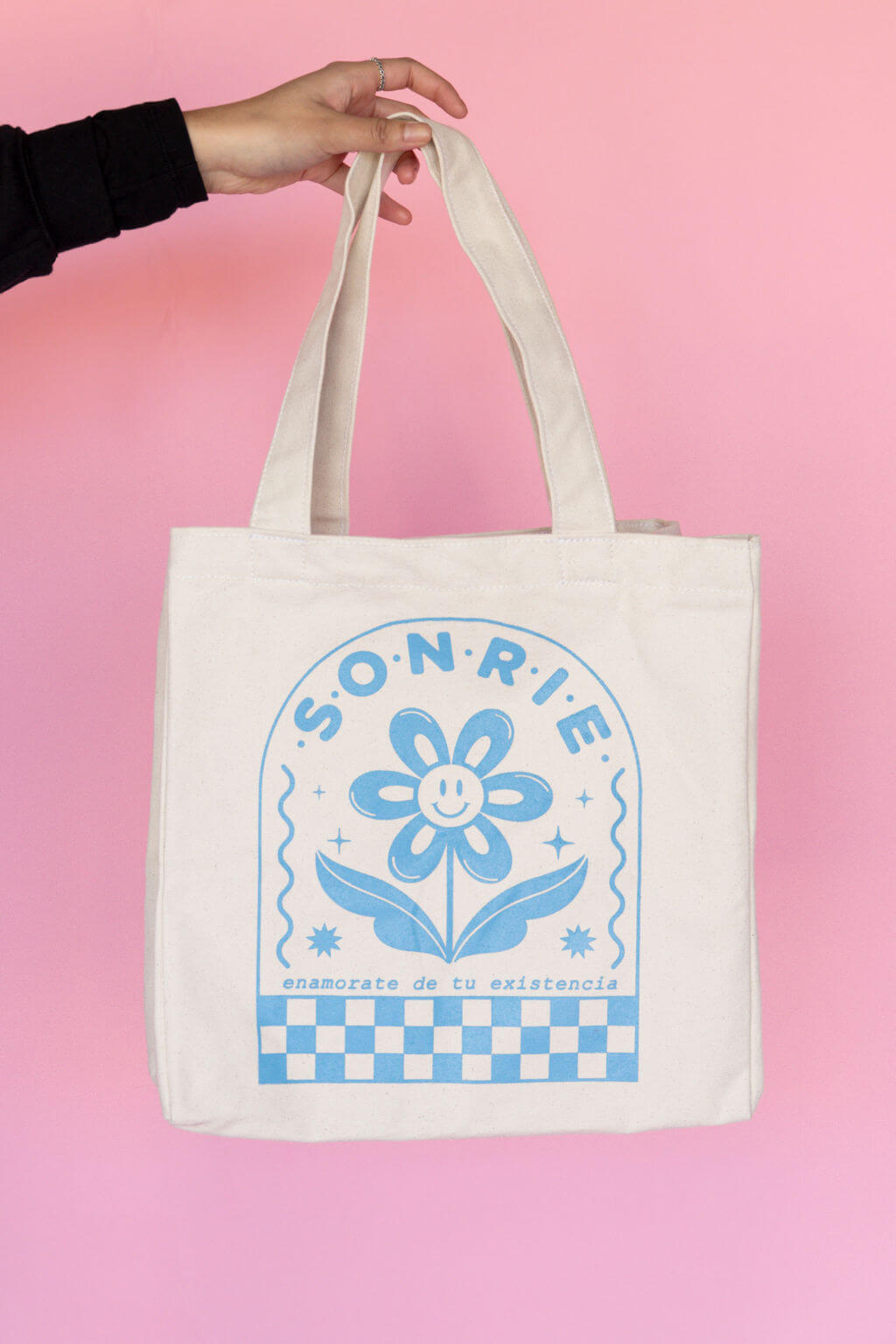White tote with soft blue flower and "Sonrie" print