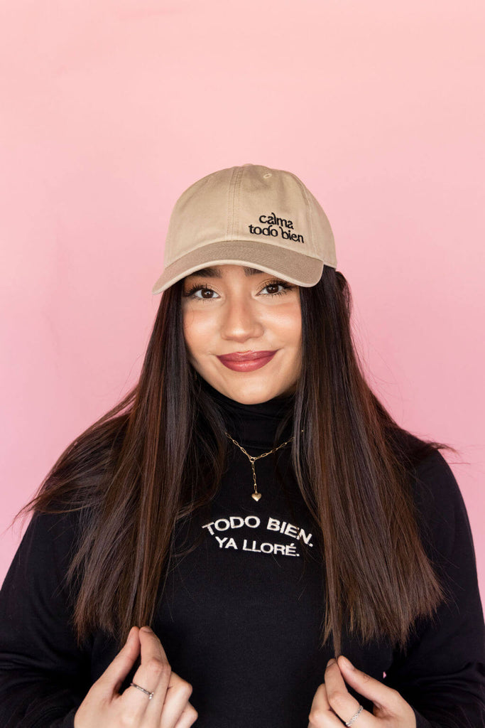 model wearing khaki dad hat with black embroidered detail